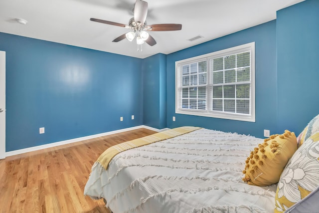 bedroom featuring wood finished floors, baseboards, and ceiling fan