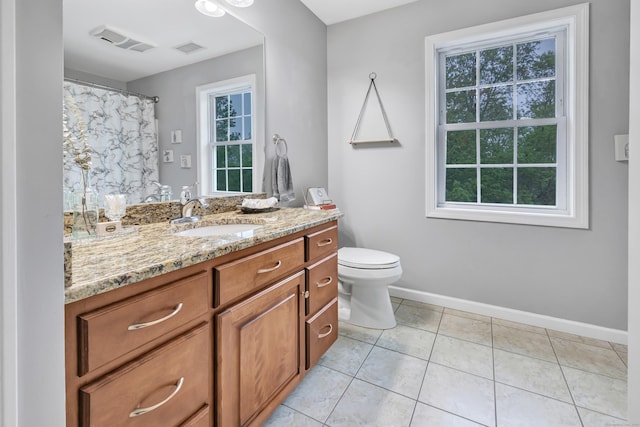 bathroom featuring baseboards, toilet, vanity, and tile patterned floors