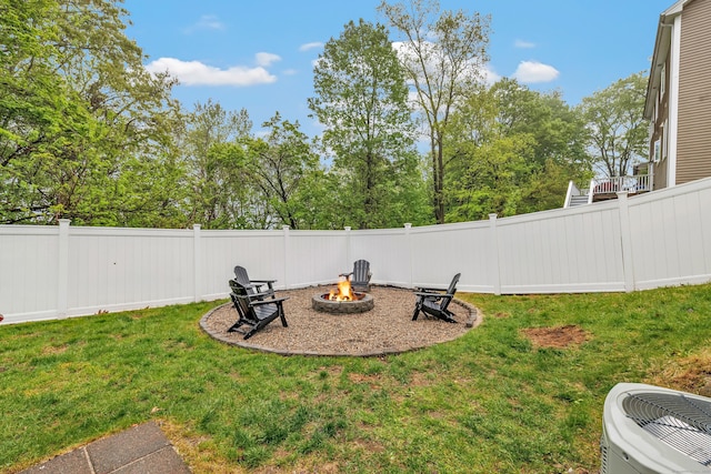 view of yard featuring a fire pit and central air condition unit