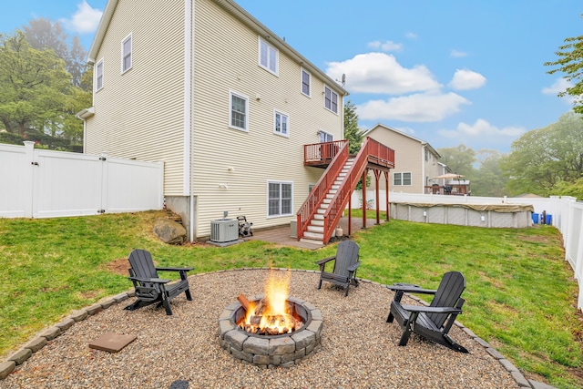 back of property with a fire pit, stairway, cooling unit, a deck, and a gate
