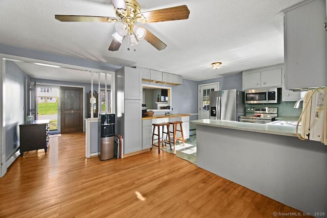 20 Sims Rd, Bristol, CT 06010 - kitchen with a sink, light wood-style floors, stainless steel appliances, light countertops, and a peninsula