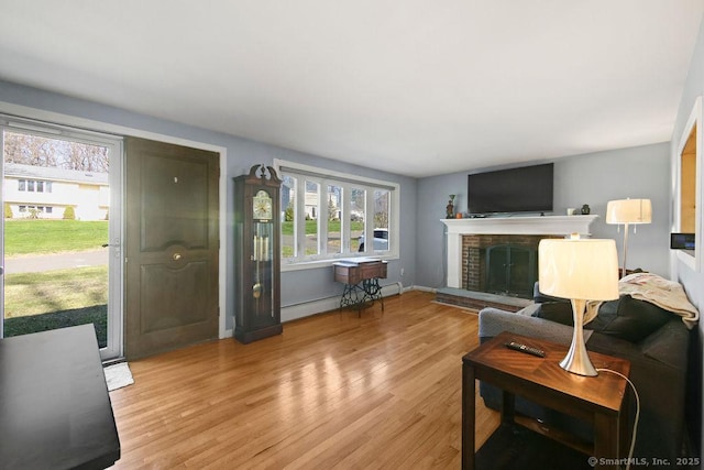 20 Sims Rd, Bristol, CT 06010 - living room with a baseboard heating unit, baseboards, a brick fireplace, and wood finished floors