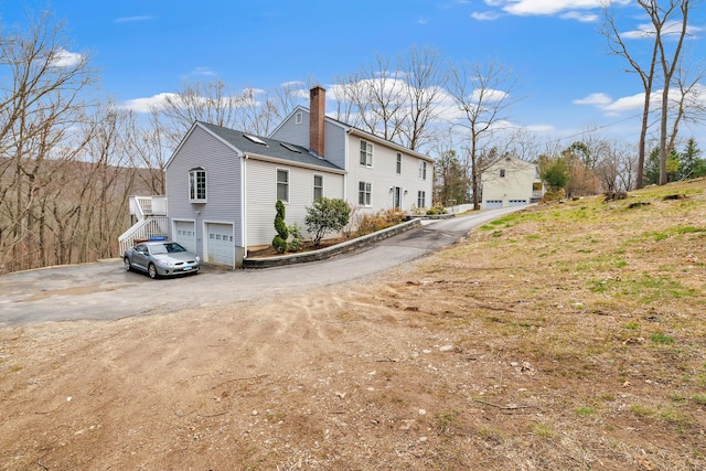 190 Thoreau Dr, Shelton, CT 06484 - view of side of property with a chimney, aphalt driveway, and a garage