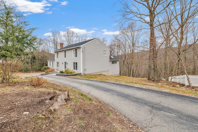 190 Thoreau Dr, Shelton, CT 06484 - view of property exterior featuring fence, a chimney, and aphalt driveway