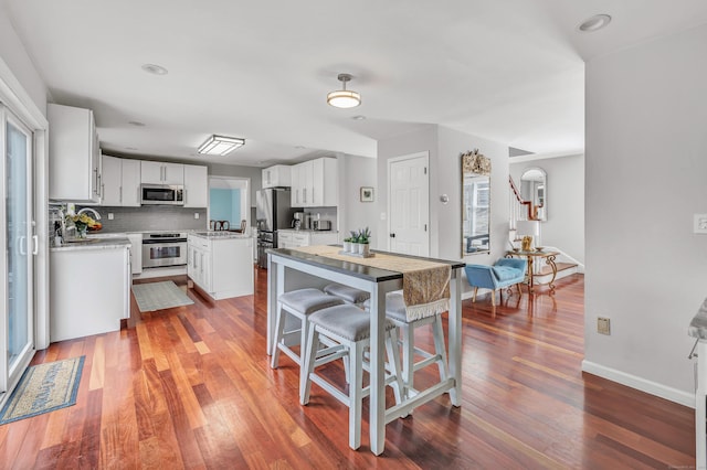 190 Thoreau Dr, Shelton, CT 06484 - kitchen featuring decorative backsplash, a center island, wood finished floors, and stainless steel appliances