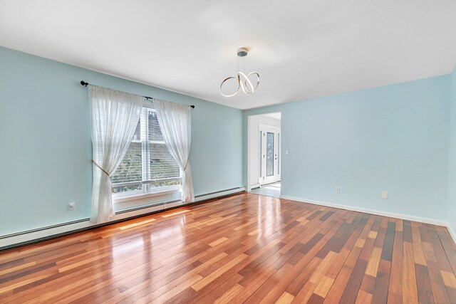 190 Thoreau Dr, Shelton, CT 06484 - spare room with baseboards, baseboard heating, wood finished floors, and a notable chandelier