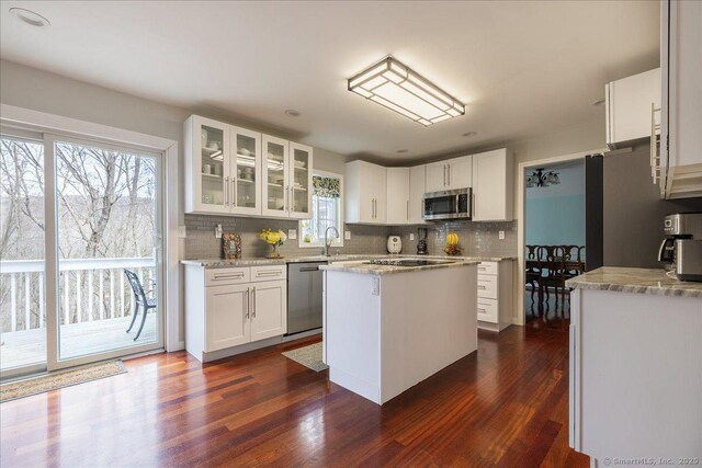 190 Thoreau Dr, Shelton, CT 06484 - kitchen with appliances with stainless steel finishes, tasteful backsplash, dark wood-type flooring, white cabinetry, and glass insert cabinets