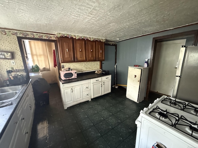 148 Plymouth St, New Haven, CT 06519 - kitchen with white gas range, dark countertops, a textured ceiling, and a sink