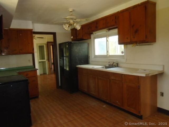 35 Greenhouse Blvd, West Hartford, CT 06110 - kitchen featuring brown cabinets, freestanding refrigerator, a ceiling fan, and a sink