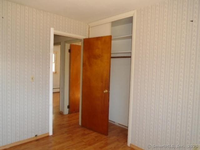 35 Greenhouse Blvd, West Hartford, CT 06110 - unfurnished bedroom featuring a baseboard radiator, wood finished floors, and a closet