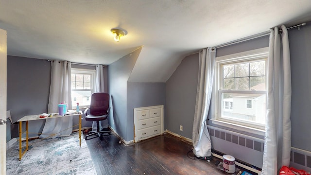 office featuring radiator, lofted ceiling, wood finished floors, and baseboards