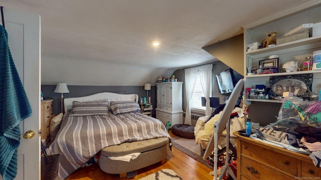bedroom featuring lofted ceiling and wood finished floors