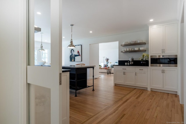 kitchen featuring pendant lighting, white cabinetry, open shelves, oven, and light wood-type flooring