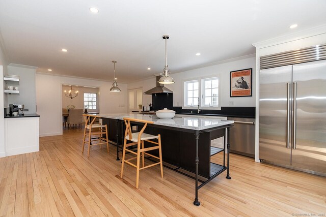 kitchen featuring recessed lighting, light wood-style floors, built in refrigerator, a center island, and ornamental molding