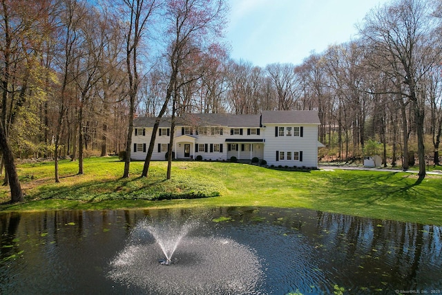back of house with a yard and a water view