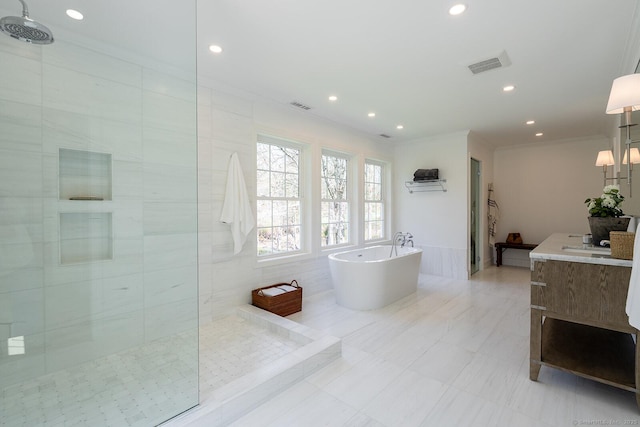 bathroom featuring recessed lighting, a walk in shower, a freestanding tub, ornamental molding, and vanity