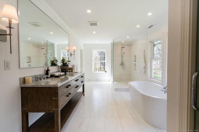 full bath with visible vents, a freestanding tub, tiled shower, and a sink