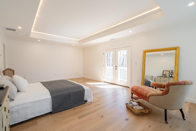bedroom featuring a raised ceiling, visible vents, access to exterior, light wood finished floors, and french doors