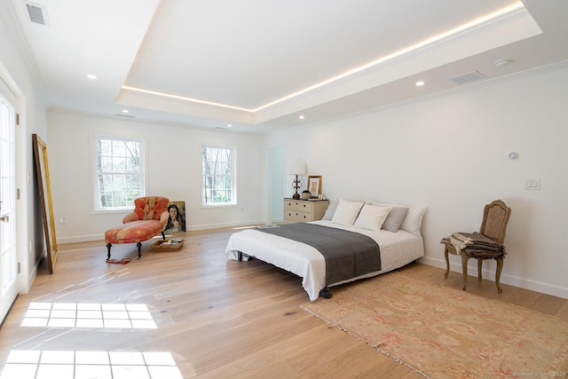 bedroom with a raised ceiling, recessed lighting, visible vents, and light wood-style floors