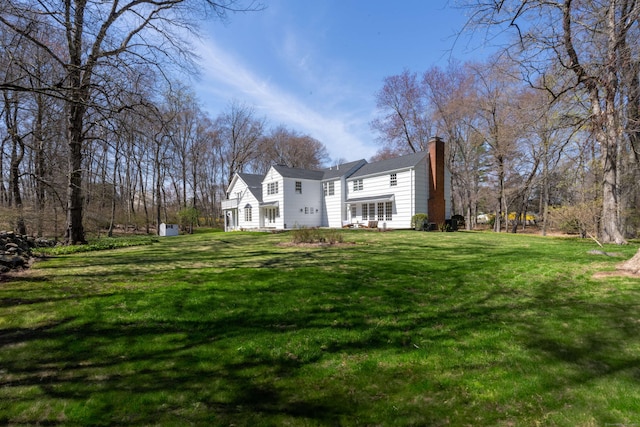 exterior space featuring a chimney and a front yard