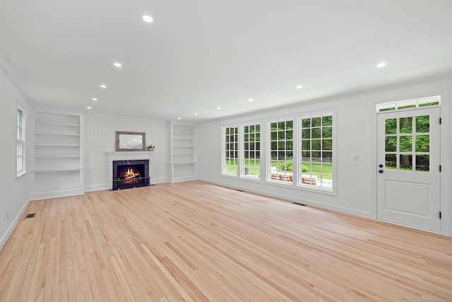 148 W Hills Rd, New Canaan, CT 06840 - unfurnished living room with built in shelves, ornamental molding, light wood-style flooring, a fireplace with flush hearth, and recessed lighting