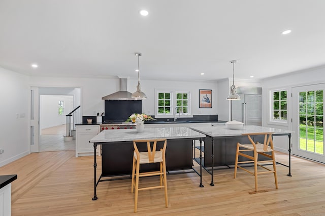 148 W Hills Rd, New Canaan, CT 06840 - kitchen with stainless steel built in refrigerator, wall chimney range hood, a center island, a sink, and healthy amount of natural light