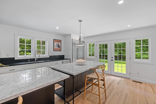 148 W Hills Rd, New Canaan, CT 06840 - kitchen featuring a sink, a kitchen breakfast bar, ornamental molding, white cabinets, and french doors