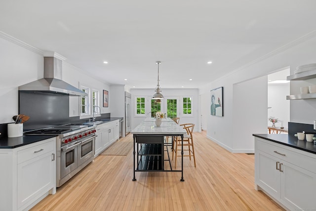 148 W Hills Rd, New Canaan, CT 06840 - kitchen with wall chimney range hood, premium appliances, light wood finished floors, white cabinetry, and recessed lighting