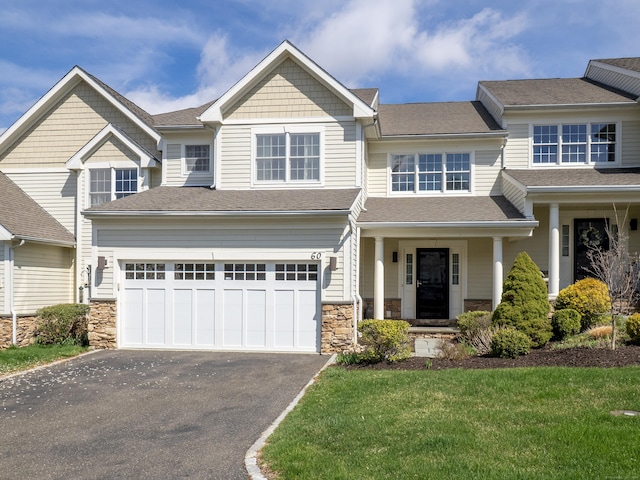 view of front of house with a garage, aphalt driveway, a shingled roof, and stone siding