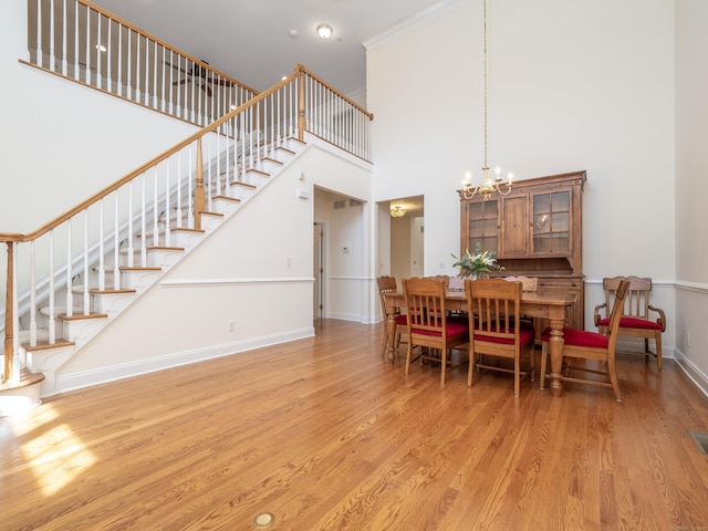 dining area with a notable chandelier, stairway, and wood finished floors