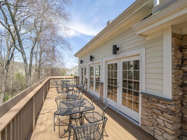 wooden terrace featuring outdoor dining space and french doors