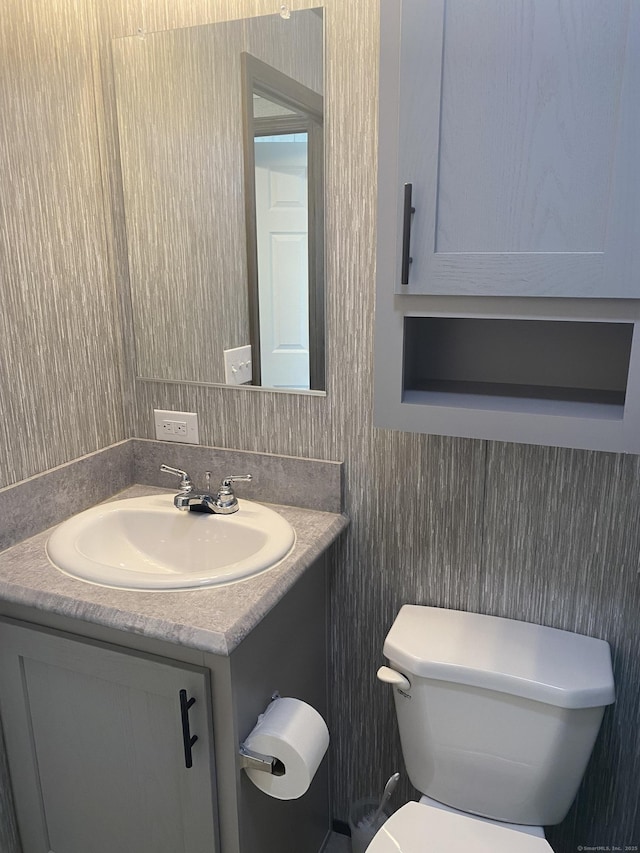 half bath featuring toilet and vanity