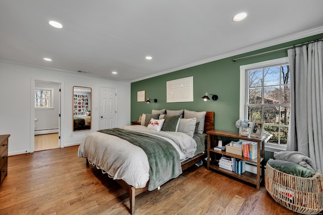 bedroom with multiple windows, visible vents, a baseboard radiator, and crown molding