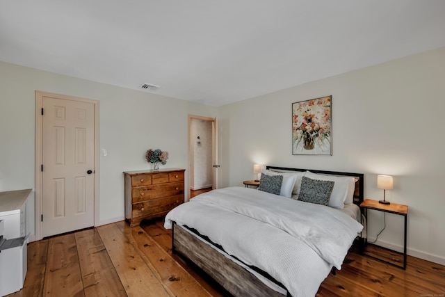 bedroom featuring hardwood / wood-style flooring, baseboards, and visible vents
