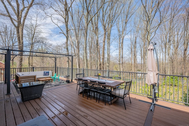 wooden terrace with a gazebo, outdoor dining space, and an outdoor hangout area