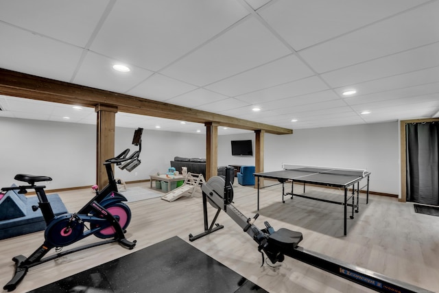exercise room with light wood finished floors, baseboards, recessed lighting, and a drop ceiling