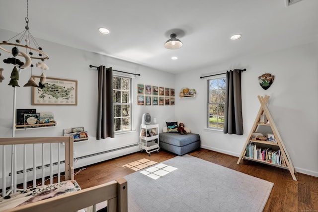 bedroom featuring baseboards, wood finished floors, recessed lighting, and a baseboard radiator