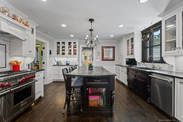 101 N Main St, Essex, CT 06426 - kitchen with stainless steel appliances, white cabinets, dark countertops, a sink, and a notable chandelier