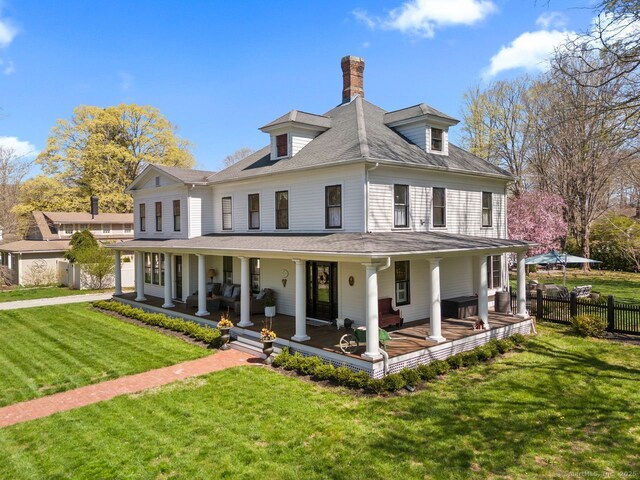 101 N Main St, Essex, CT 06426 - view of front of house featuring a porch, a front yard, a chimney, roof with shingles, and fence
