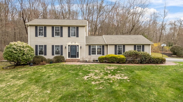 colonial inspired home featuring entry steps and a front yard