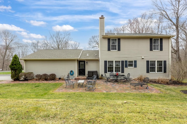 back of property featuring a patio area, a yard, and a chimney