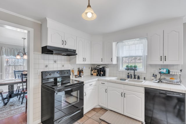 kitchen featuring a sink, black appliances, tile counters, under cabinet range hood, and white cabinetry