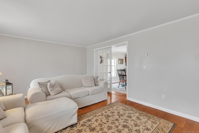 living room with baseboards, ornamental molding, and wood finished floors