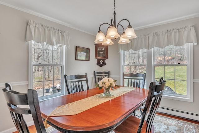 dining space featuring crown molding, an inviting chandelier, plenty of natural light, and wood finished floors