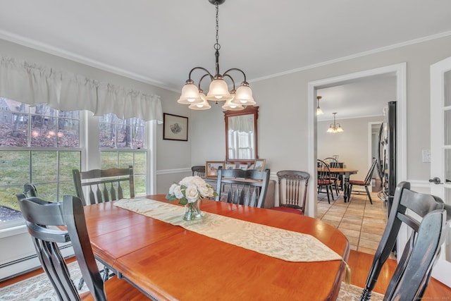 dining space with light tile patterned floors, ornamental molding, and a notable chandelier