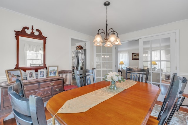 dining area featuring ornamental molding and a notable chandelier