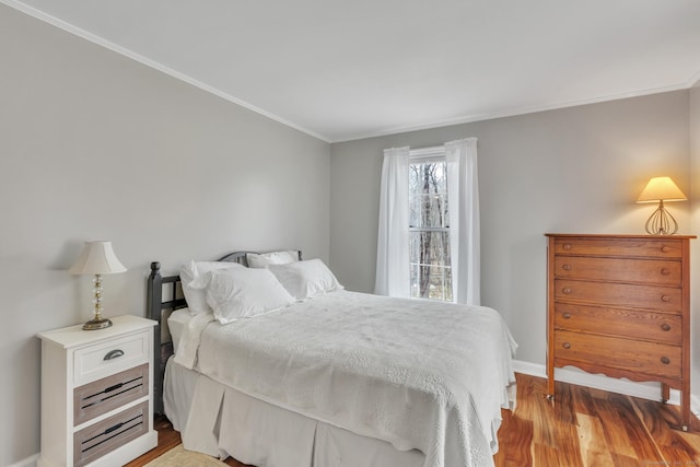 bedroom with light wood-type flooring, ornamental molding, and baseboards