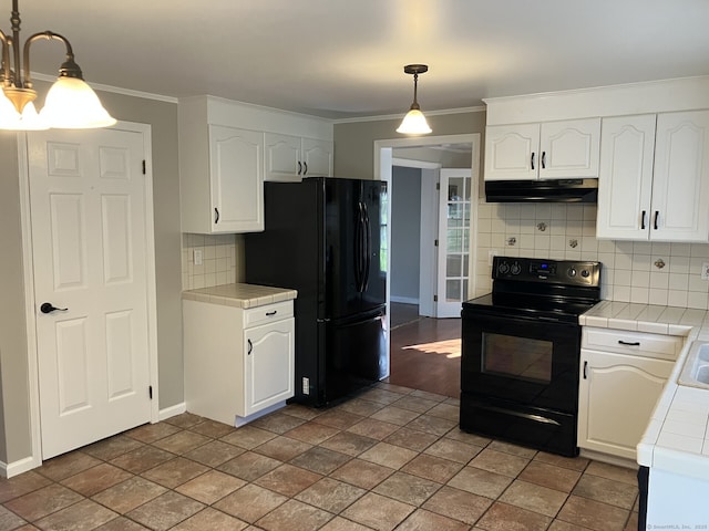 kitchen featuring tile counters, white cabinetry, tasteful backsplash, under cabinet range hood, and black appliances