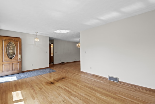 246 Sea Hill Rd, North Branford, CT 06471 - entryway with a chandelier, light wood-style flooring, baseboards, and a skylight