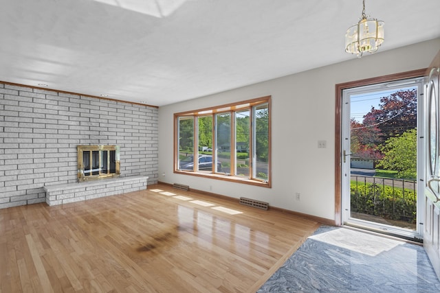 246 Sea Hill Rd, North Branford, CT 06471 - unfurnished living room featuring wood finished floors, plenty of natural light, a chandelier, and a fireplace